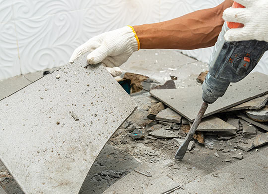 worker removing old floor tiles